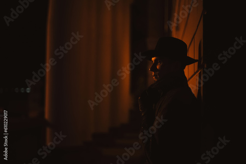 male mafia detective in a hat and raincoat at night in the style of film noir