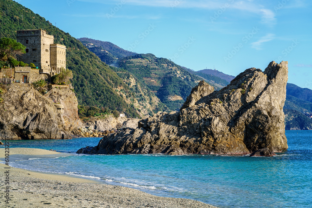 Scenic view of Monterosso al Mare in Cinque Terre National Park with medieval stone castle Down Tower, green hills and cliffs over a sea, Liguria region of Italy. Outdoor travel background