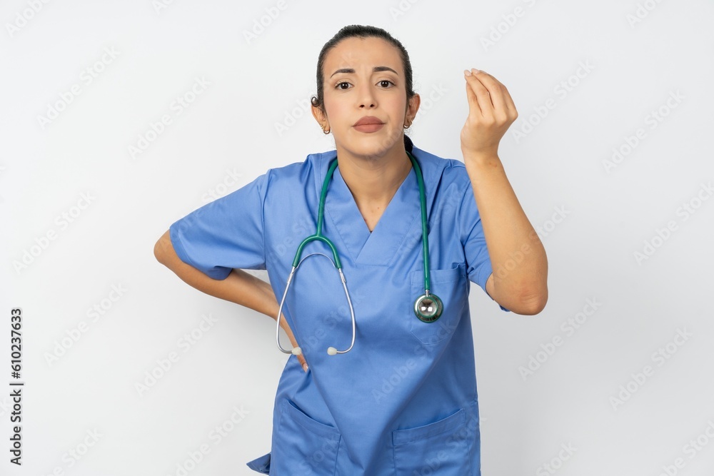 Young doctor woman wearing blue uniform over isolated background angry gesturing typical italian gesture with hand, looking to camera Young doctor woman wearing blue uniform over isolated background angry gesturing typical italian gesture with hand, looking to camera