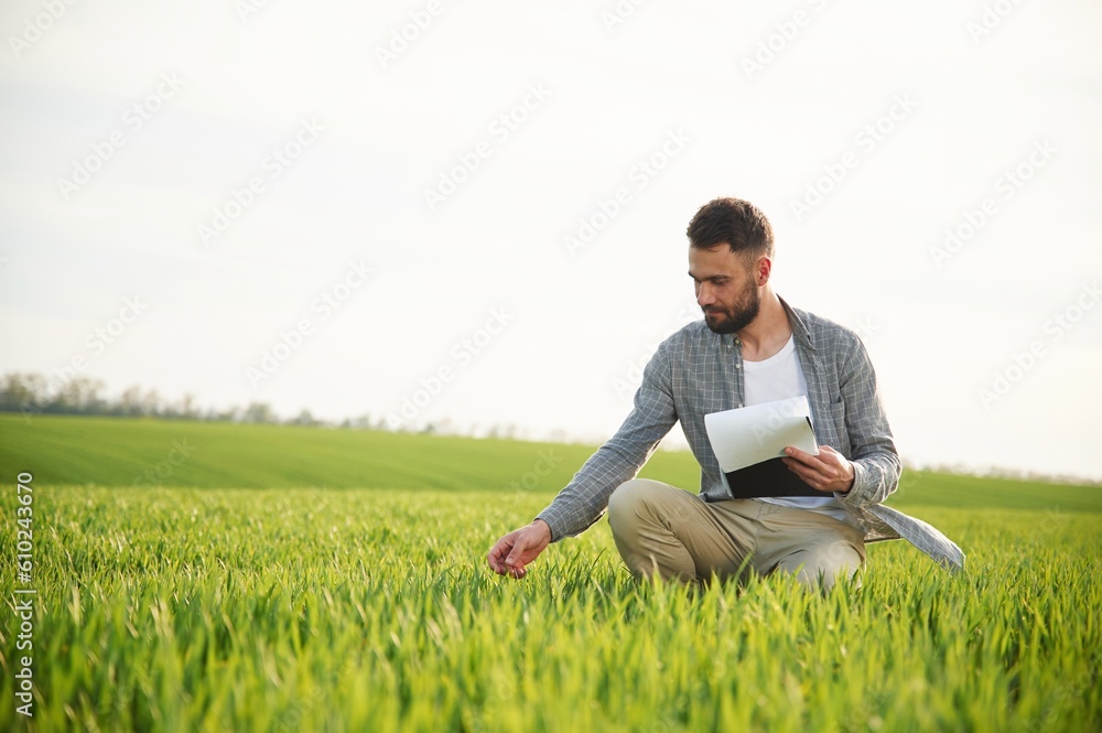 With notepad in hands. Handsome young man is on agricultural field With notepad in hands. Handsome young man is on agricultural field