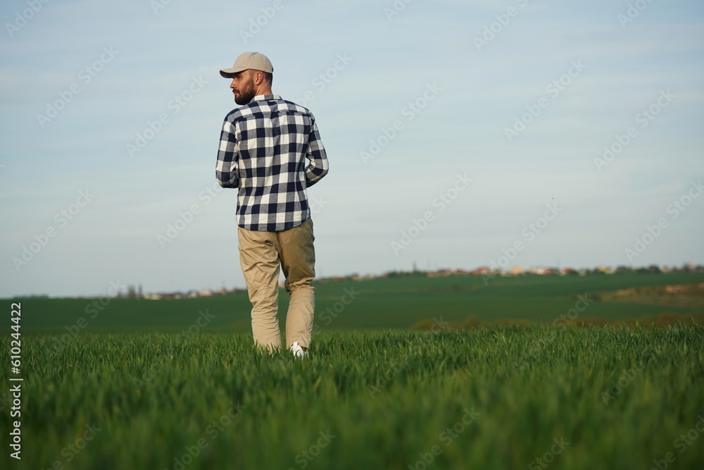 Clear sky. Handsome young man is on agricultural field