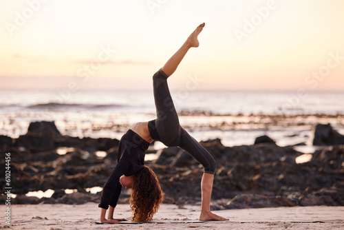 Woman, beach and stretching leg for yoga, chakrasana or sunset for body, health or fitness and mindfulness. Girl. workout and zen meditation for peace, mindset or nature for chakra balance by ocean photo