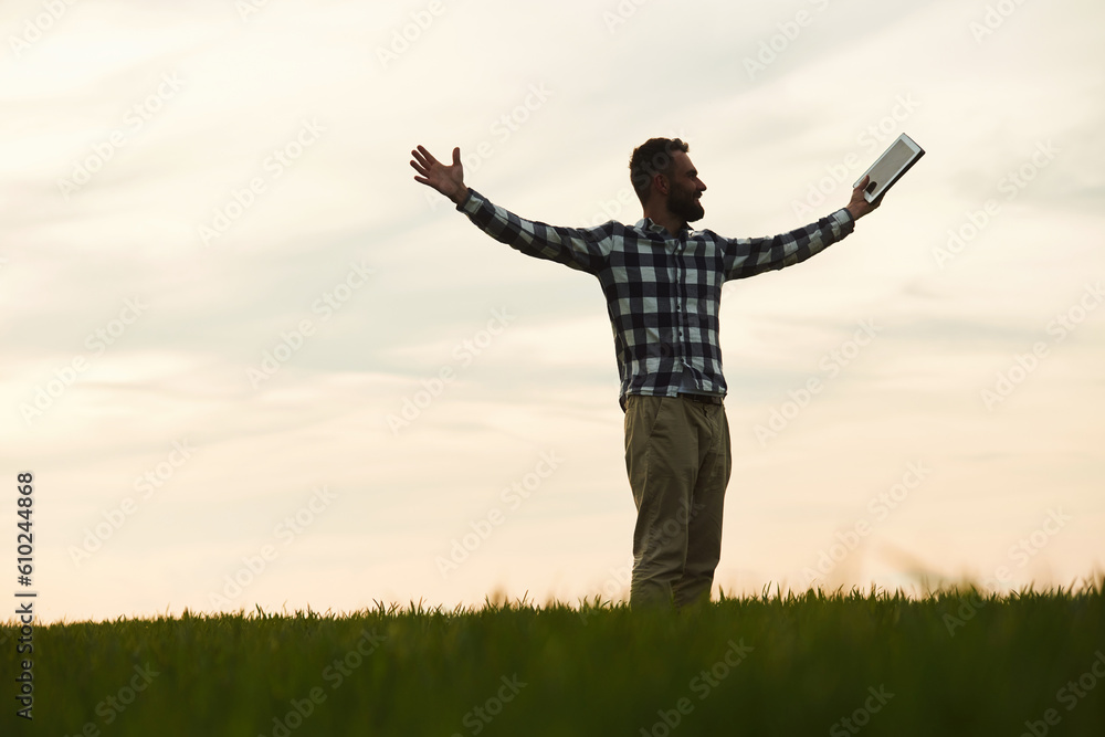 Enjoying freedom, with hands up. Handsome young man is on agricultural field Enjoying freedom, with hands up. Handsome young man is on agricultural field