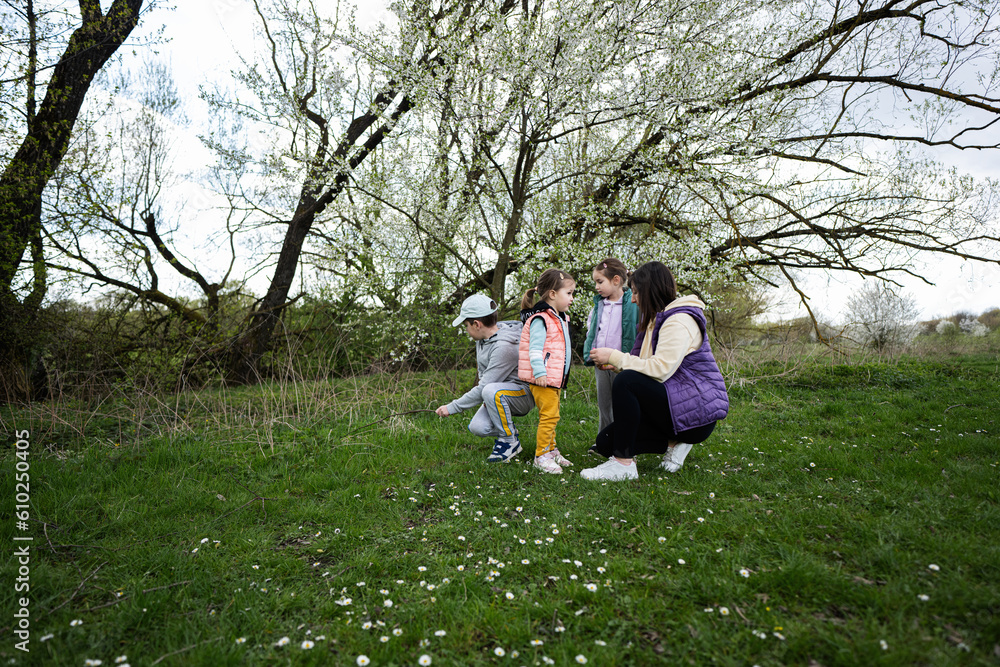 Mother with three kids in spring meadow. Mother with three kids in spring meadow.