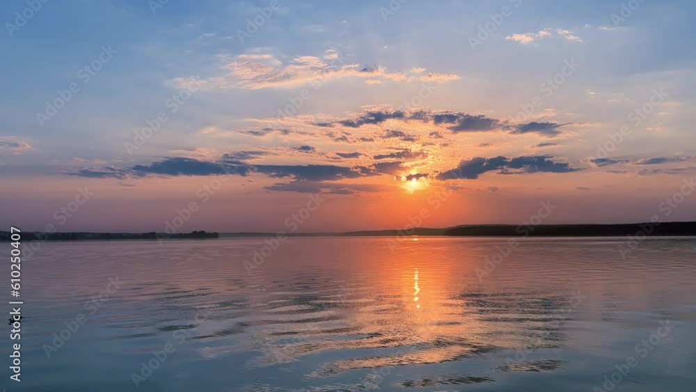 A solar eclipse during a mesmerizing fiery sunset. Majestic sunset or sunrise landscape. Sunset with reflection in the water. The sun and clouds were reflected in the water. Fiery sunset. Russia A solar eclipse during a mesmerizing fiery sunset. Majestic sunset or sunrise landscape. Sunset with reflection in the water. The sun and clouds were reflected in the water. Fiery sunset. Russia