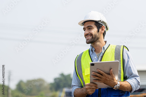 Heavy-duty industrial engineers stand in a pipeline manufacturing facility using digital tablet computers for the construction of products to transport oil, gas and fuel.