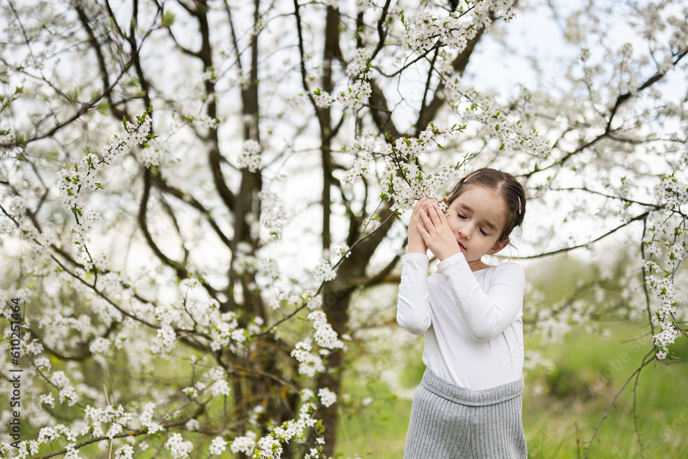 Portrait of preschool girl against white blloming tree in spring. Portrait of preschool girl against white blloming tree in spring.