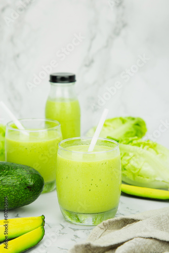 Avocado and green cos salad blended in a glass and bottle, healthy drinking water.  vertical photo