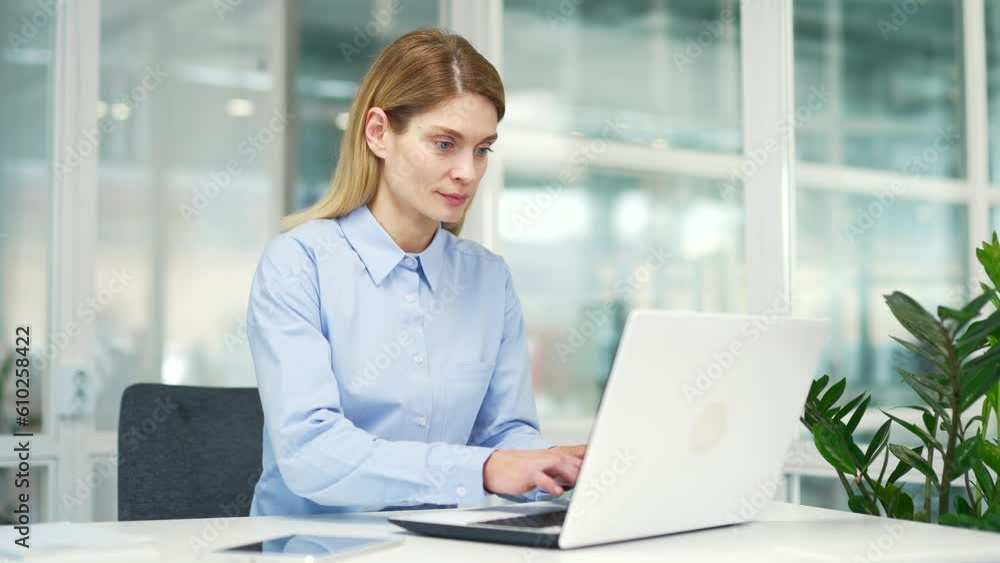 Happy excited businesswoman read great news on laptop while sitting at workplace in modern office. A smiling and satisfied mature female employee is joyfully reviewing a pleasant message notification Happy excited businesswoman read great news on laptop while sitting at workplace in modern office. A smiling and satisfied mature female employee is joyfully reviewing a pleasant message notification