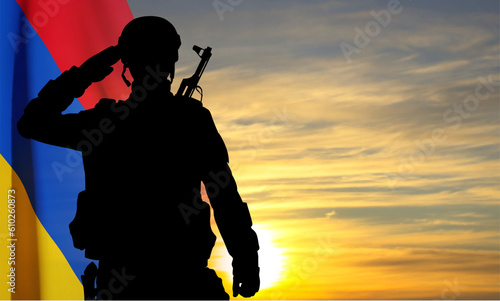 Silhouette of a saluting soldier with flag of Armenia against the sunset. EPS10 vector