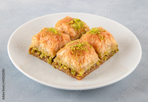 Pistachio Turkish baklava on a white plate.Close-up of four slices of baklava
