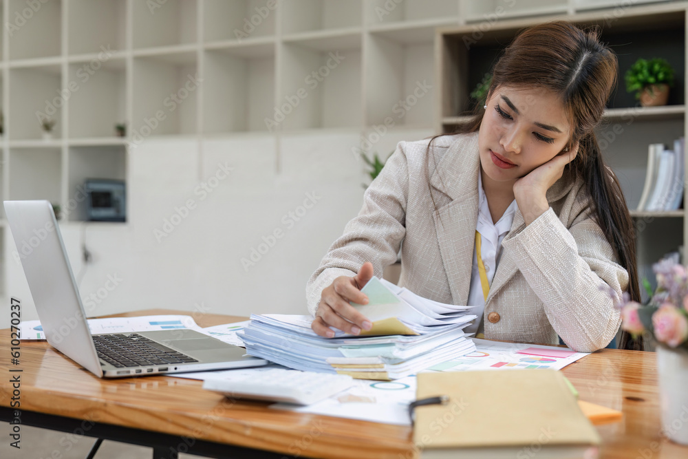 Boring young business Asian woman holding document file and work at office investment data report Financial and tax systems concept Boring young business Asian woman holding document file and work at office investment data report Financial and tax systems concept