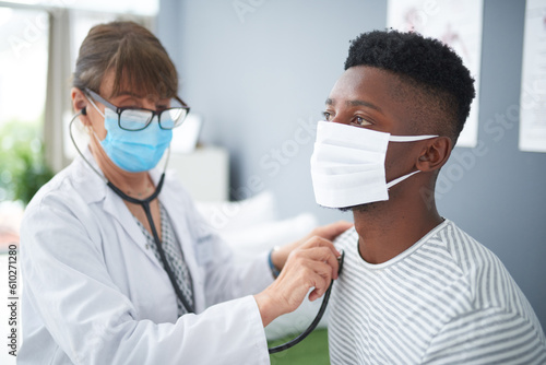 Doctor, exam and woman with patient listening to heart, breathing or medical healthcare test for covid in hospital. Clinic, black man and corona mask or sick person, check health with stethoscope
