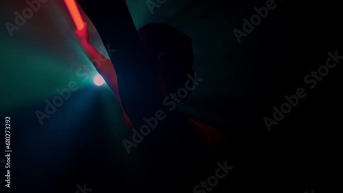 Professional female dancer improvises modern dance in light of blue and red. Attractive slender ballerina moves gracefully with glowing stick featuring contemporary choreography photo