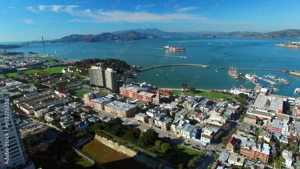 Aerial Shot Of Buildings In City Near Nautical Vessels On Sea, Drone Flying Backward Over Cityscape Against Sky On Sunny Day - San Francisco, California Aerial Shot Of Buildings In City Near Nautical Vessels On Sea, Drone Flying Backward Over Cityscape Against Sky On Sunny Day - San Francisco, California