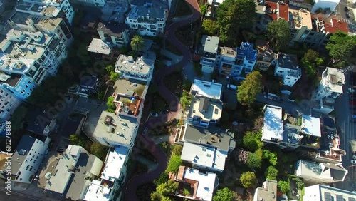 Aerial Panning Shot Of Lombard Street Amidst Buildings In City, Drone Flying Over Neighborhood On Sunny Day - San Francisco, California
