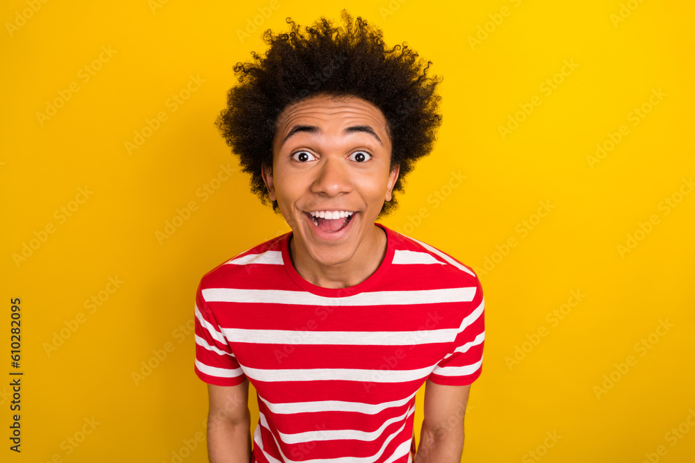 Photo of impressed shocked guy dressed red t-shirt smiling open mouth isolated yellow color background Photo of impressed shocked guy dressed red t-shirt smiling open mouth isolated yellow color background