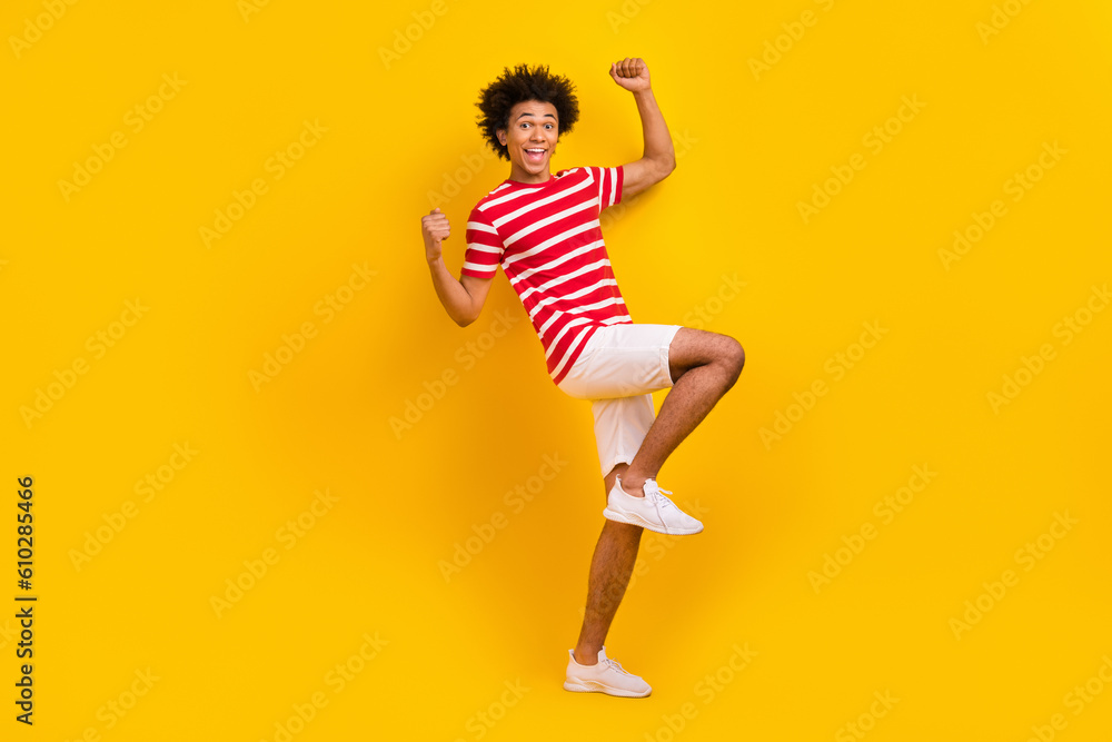 Full body photo of youth hipster guy raise fists arms up astonished wear summer shirt pants isolated yellow color background