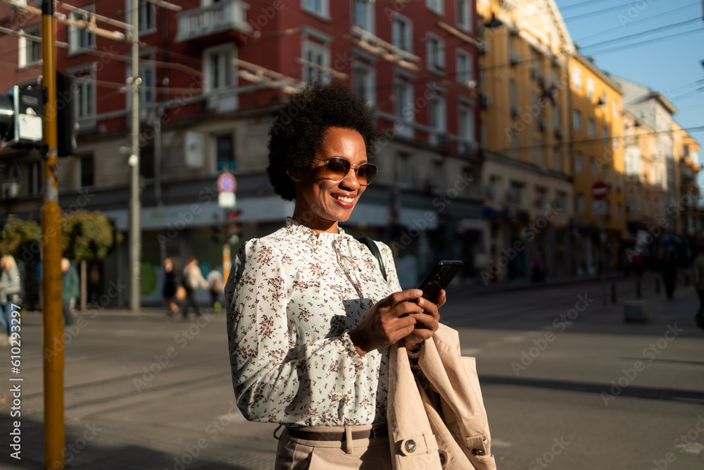 Black woman being a tourist, walking around the unknown city, using a mobile phone. Black woman being a tourist, walking around the unknown city, using a mobile phone.