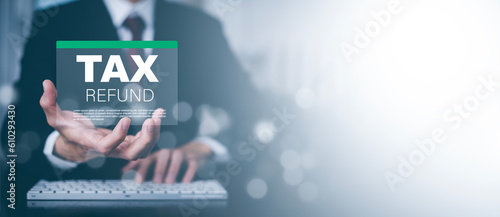 Obraz na plátne Business people hand-holding TAX REFUND and refund tax of duty taxation business, graphs and chart being demonstrated on the screen media, tablet pc and selecting tax refund