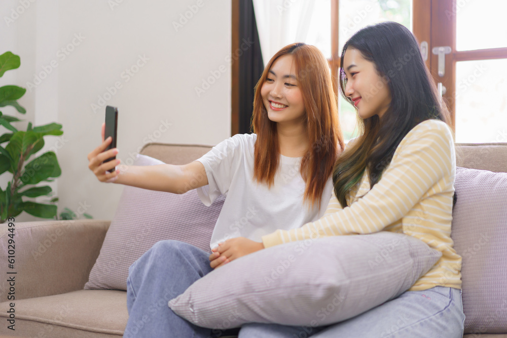 Activity at home concept, LGBT lesbian couple smiling and using smartphone to selfie together Activity at home concept, LGBT lesbian couple smiling and using smartphone to selfie together