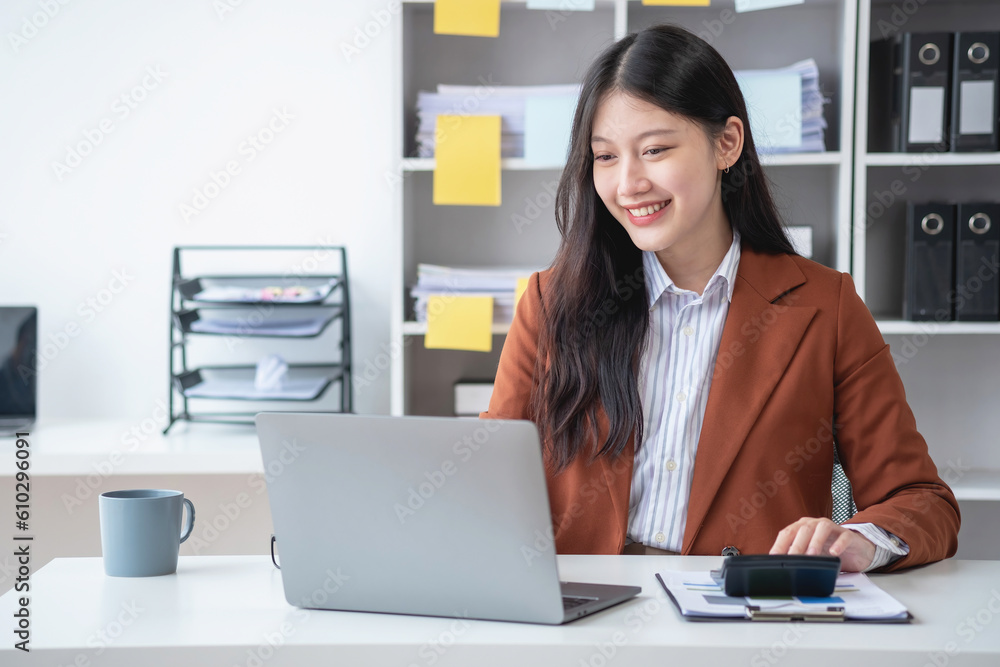 businesswoman working in the office Using calculator to calculate financial reports. Sales data with laptop computer and business documents on office table. Close up. Business finance and investment. businesswoman working in the office Using calculator to calculate financial reports. Sales data with laptop computer and business documents on office table. Close up. Business finance and investment.