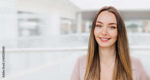 Close portrait of a young caucasian brunette woman in a beige business suit