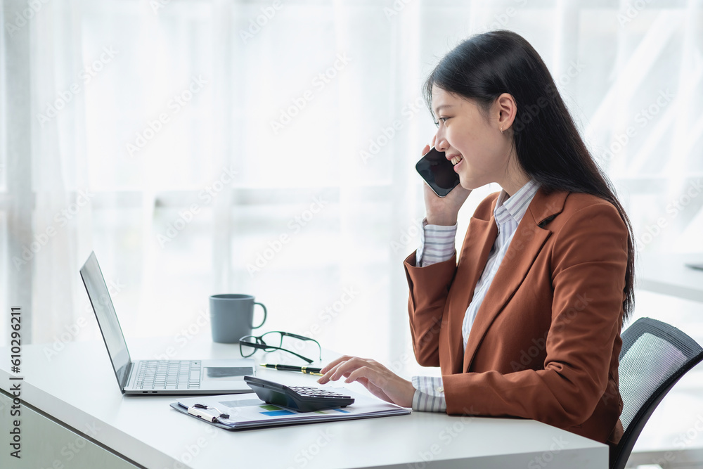 Asian businesswoman talking on the phone working in modern office Chat with clients for a new way of doing business in the office. Asian businesswoman talking on the phone working in modern office Chat with clients for a new way of doing business in the office.