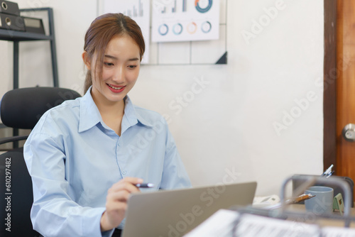 Business concept, Businesswomen reading finance document and checking data on laptop at workplace