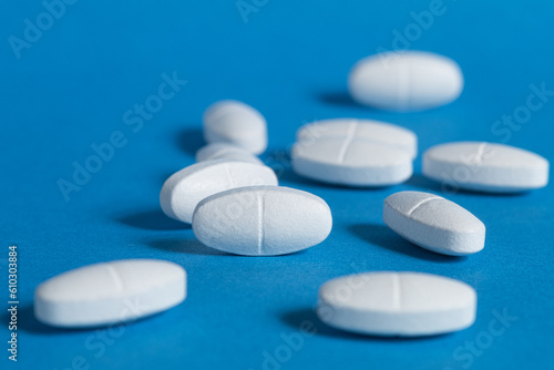 Long white pills on a blue background. White pills pattern on a blue background. Concept of medicine. long wide banner