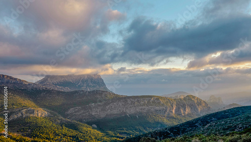 Mountains and a beautiful sky with rays of sun over the mountain Puig Campana. Mount Castellet on the right. In the Valencian Community, Alicante, Spain