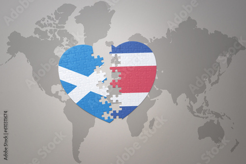 puzzle heart with the national flag of costa rica and scotland on a world map background.Concept.