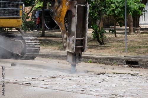 Road drilling vehicle, backhoe, yellow, attached to the drilling head, the Yak head, working