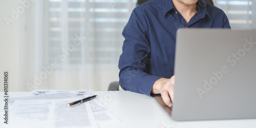 Happy businessman, male businessperson using computer laptop with paperwork on desk at office. Professional entrepreneur business man wear eyeglasses, sitting to working, planning on workplace. Banner