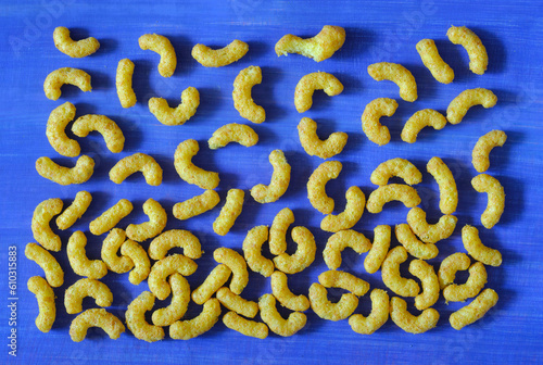 peanut curls, peanut puffs, peanut flavoured wotsits, delicious snacks, flat lay on blue background
