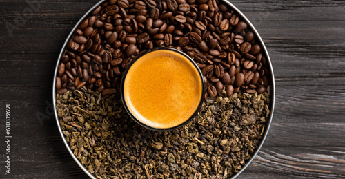 Composition of green tea, coffee beans and coffee in a cup on a dark background top view.