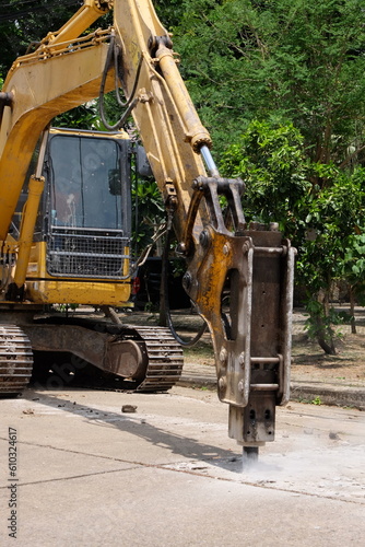 Road drilling vehicle, backhoe, yellow, attached to the drilling head, the Yak head, working
