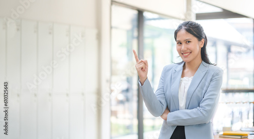 Successful businesswoman standing in modern office and pointing at copy space. Free Download Successful businesswoman standing in modern office and pointing at copy space. - GFXLoad