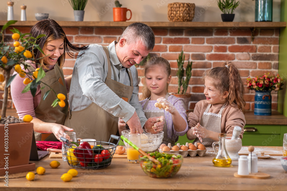 In the morning happy young family cooking their favourite deserts the dad charismatic man mixed the dough while other family members helping him at the kitchen island