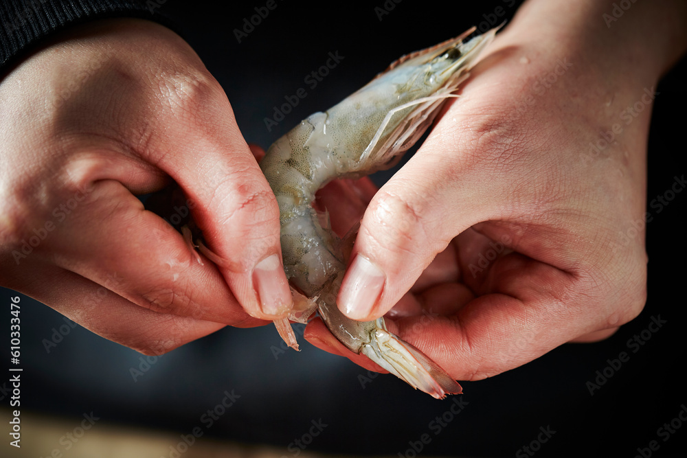 Close-up of hands trimming shrimp
