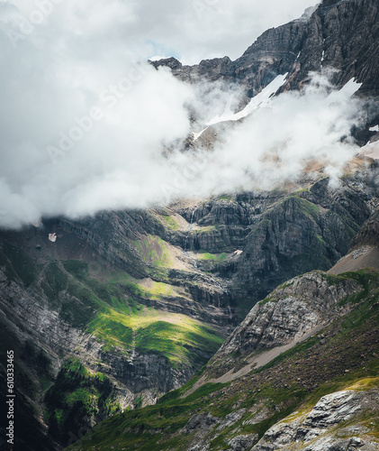 mountain landscape with sunlight into clouds and a waterfall