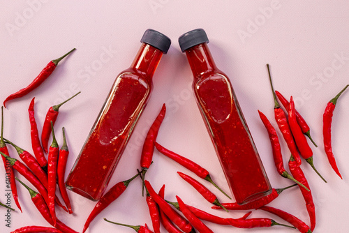 Fotografie Tabasco hot pepper sauce with red chili pepper, flat lay
