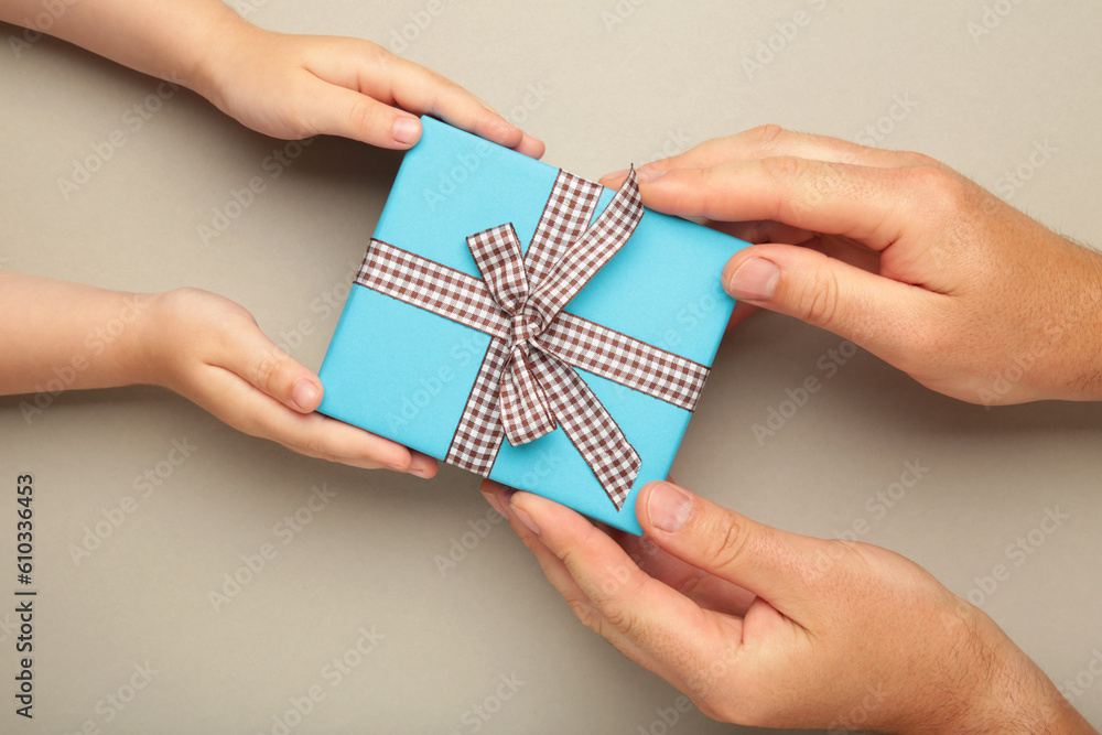 Father's day gift with daughter or son holding dad's hands giving present box to tell I love you dad, I am so thankful and happy fathers day.
