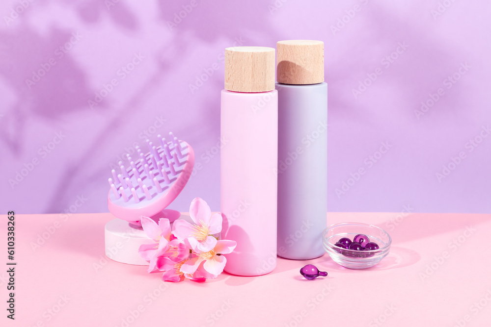 Mockup shampoo and conditioner bottles with shampoo brush and hair vitamins on vibrant pink background Mockup shampoo and conditioner bottles with shampoo brush and hair vitamins on vibrant pink background