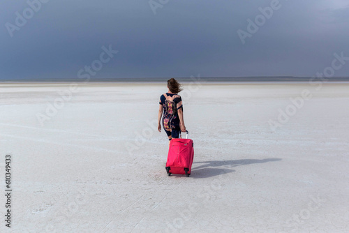 The girl with the red. with a suitcase on the Kazakh Salt Marsh photo