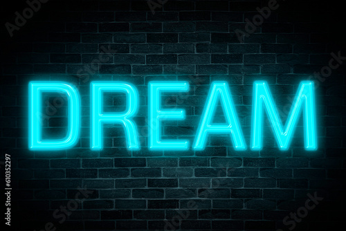 Dream neon banner on brick wall background.