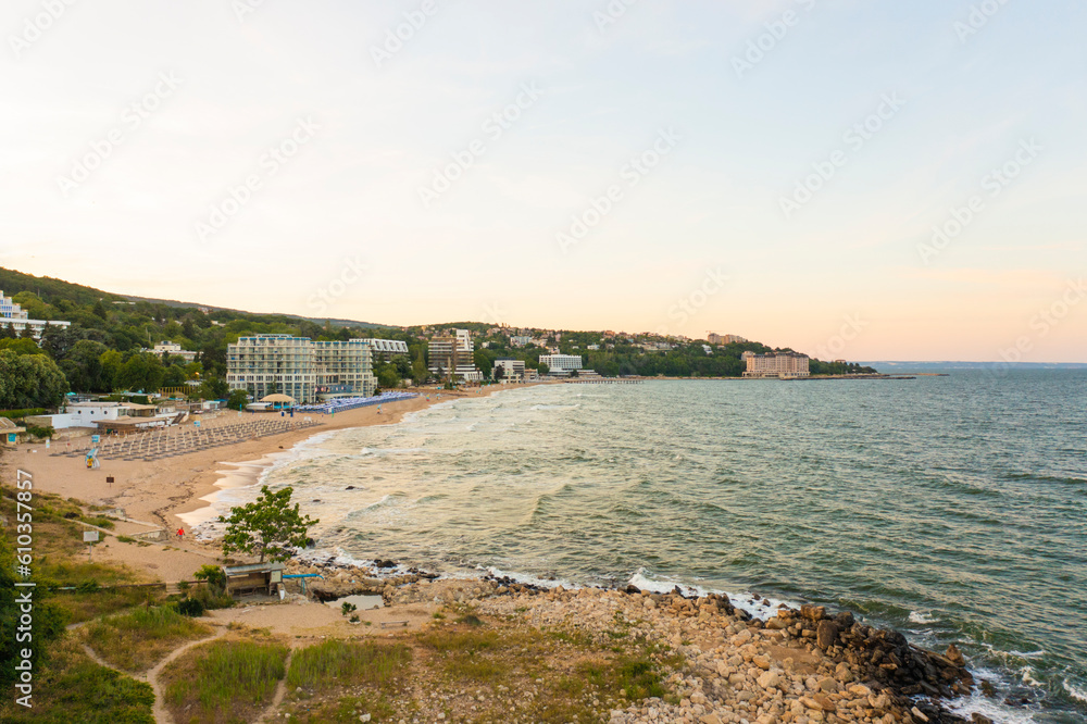 Panoramic bird view of seacoast and sandy beach at sunset golden hour. Black sea vacation concept