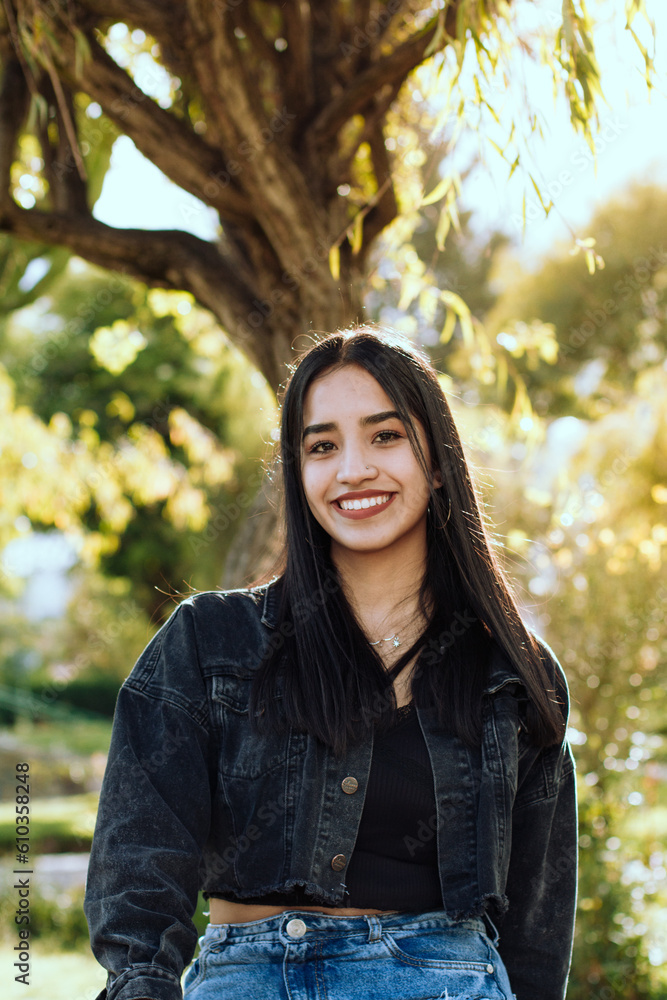 Portrait photo of smiling young woman outdoors with sunlight. Concept of people and lifestyle. Portrait photo of smiling young woman outdoors with sunlight. Concept of people and lifestyle.