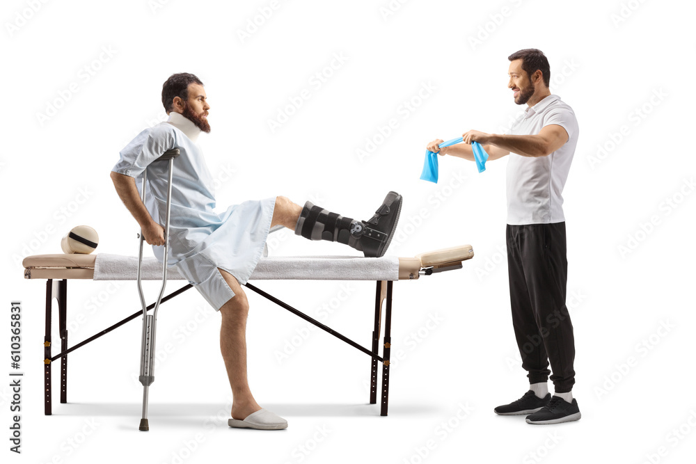 Injured man in a hospital gown and a physical therapist showing exercises with a resistance band Injured man in a hospital gown and a physical therapist showing exercises with a resistance band