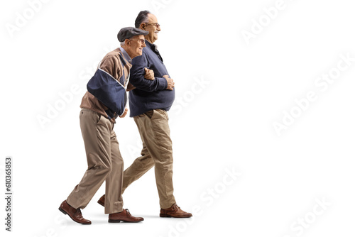 Man walking with a senior man with an injured arm in a sling
